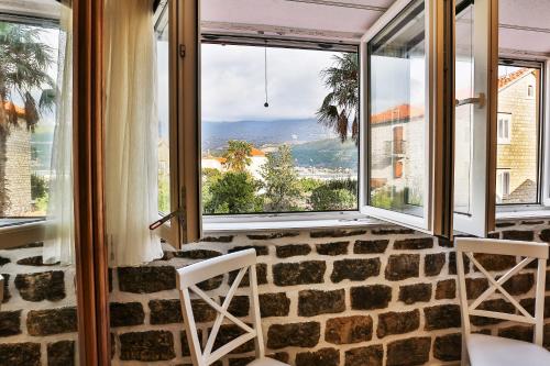 a room with two chairs and a large window at Basilica Apartments in Budva
