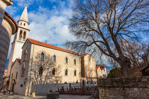 a large building with a tower and a church at Basilica Apartments in Budva