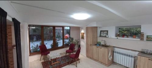 a living room with red chairs and a table and windows at Zovkenburg in Zovkʼ