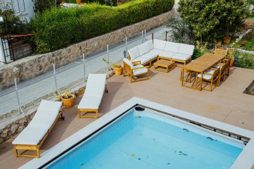 a swimming pool with lounge chairs and a table and a table and chairsktop at Sotiris House in Kazaphani