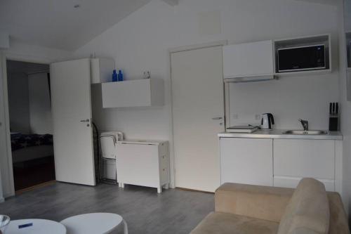 a living room with white cabinets and a couch at Calm villa-apartement near the sea and nature in Klagshamn