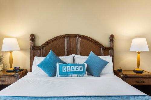 uma cama com almofadas azuis e um sinal de cama em Mahana 517 em Kahana