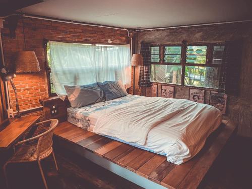 um quarto com uma cama num quarto com uma janela em Monsamkien Farmstay em Phayao