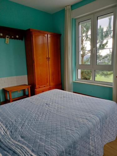 a bedroom with a bed and a dresser and two windows at Hotel Capellan in Navia