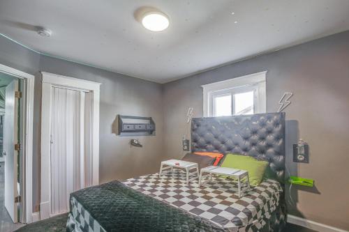 um quarto com uma cama com uma colcha de cama em xadrez em St Louis Home with Mini Pool Table and Arcade Game! em Clayton