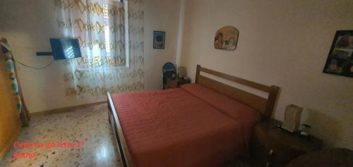 una camera con un letto con una coperta rossa di Casetta mia a Favignana