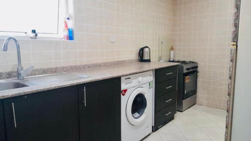 a kitchen with a washing machine and a sink at AMAZING Couples private room close to Mall of Emirates in Dubai