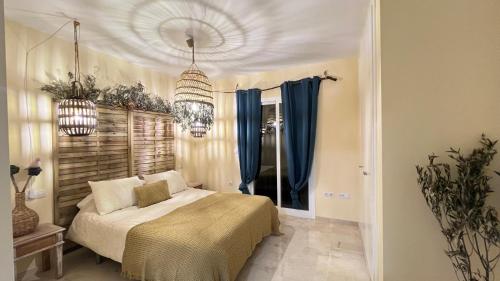a bedroom with a bed and two chandeliers at Casa Pez in Ayamonte
