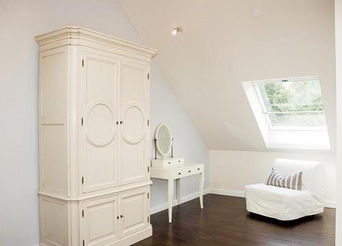 a white cabinet in a room with a mirror at SEEBADHOF - Landhaus Kaiser in Rangsdorf