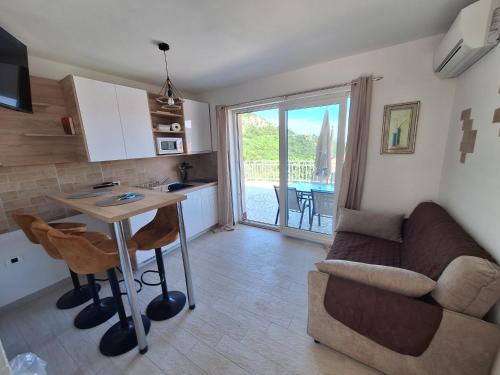 eine Küche und ein Wohnzimmer mit einem Sofa und einem Tisch in der Unterkunft Apartment Modric in Lovranska Draga