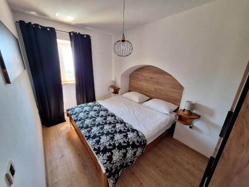 Schlafzimmer mit einem Bett und einem Fenster in der Unterkunft Apartment Modric in Lovranska Draga