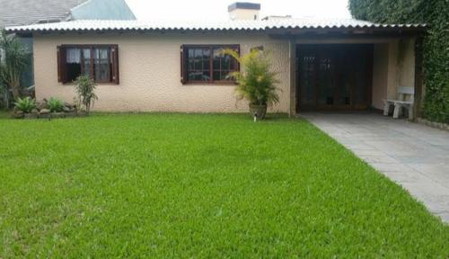 een huis met een groen gazon ervoor bij Casa Capao da Canoa in Capão da Canoa