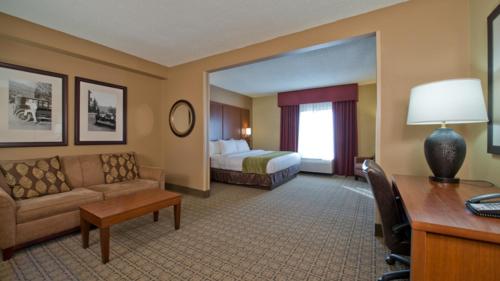 a hotel room with a couch and a bed at Russell Inn and Suites in Starkville