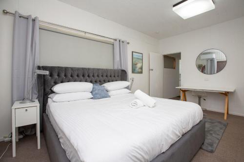 a bedroom with a large bed with a large window at CitySide Pad in Tamworth
