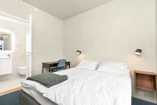 a bedroom with a white bed and a desk at Central Guest House - Bedroom with private Bathroom in Stavanger