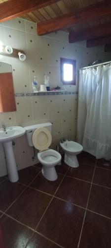 a bathroom with two sinks and a toilet and a window at Ariel in Gobernador Gregores