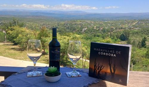 a bottle of wine and two glasses on a table at AYRES SUITE in Villa Carlos Paz
