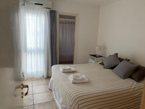 a bedroom with a large bed with two towels on it at Departamento quinta sección in Mendoza