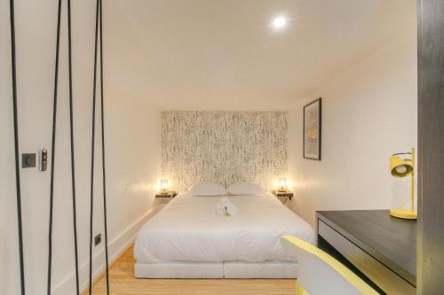 um quarto com uma cama branca e 2 candeeiros em Tiny-duplex em Lyon