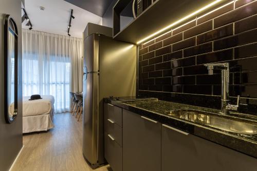 a kitchen with a sink and a black brick wall at House of Charlie Vila Mariana in São Paulo