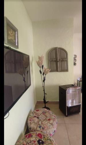 a room with a table and a vase with flowers at شقق مفروشه يومي واسبوعي in Amman
