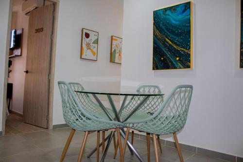 a dining room table with two chairs and a painting at GRAND HOTEL JAMUNDI in Jamundí