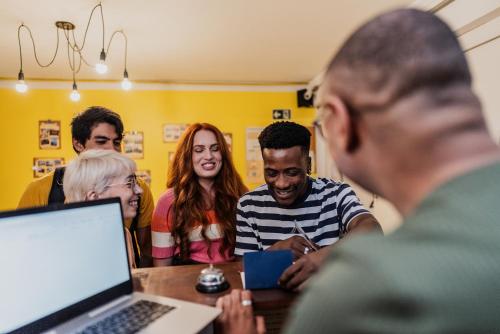 a group of people sitting around a table with a laptop at Lamparina Hostel in Sao Paulo