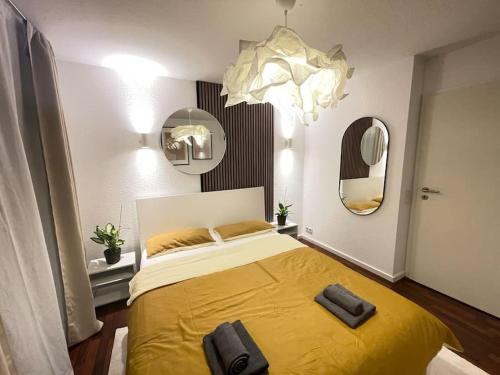 Un dormitorio con una gran cama amarilla con espejo en Charmantes TinyHouse im Zentrum - MalliBase Apartments, en Hannover