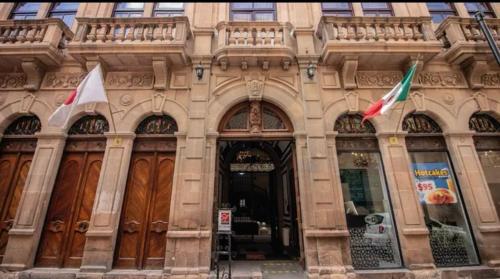a building with two flags in front of it at Hotel San Francisco in San Luis Potosí