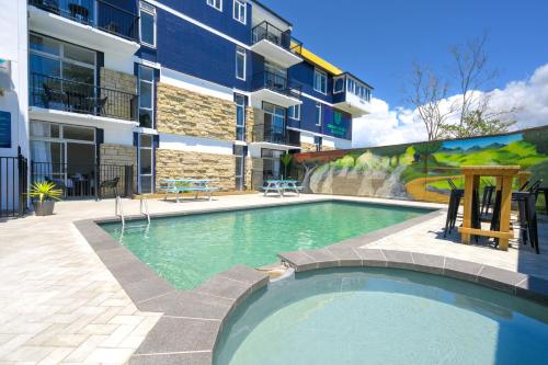 a swimming pool in front of a building at Urban Lounge Sleepery in Rotorua