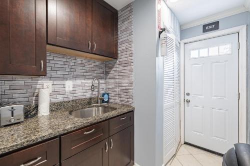 uma cozinha com um lavatório e uma porta branca em Cozy Modern 2BR Apartment in DC em Washington