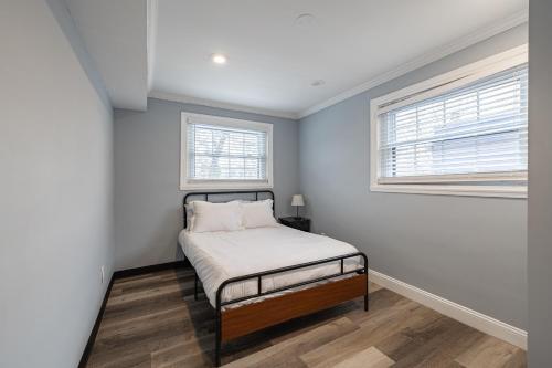 1 dormitorio pequeño con 1 cama y 2 ventanas en Cozy Modern 2BR Apartment in DC en Washington