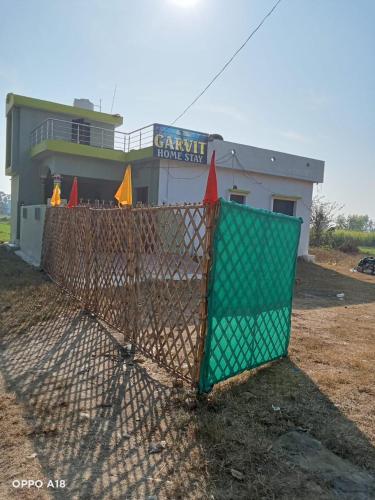 a chain link fence in front of a house at Garvita home stay in Belparāo