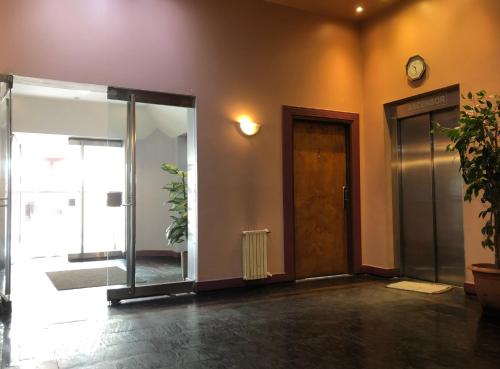 ein leeres Zimmer mit einer Tür und einer Uhr an der Wand in der Unterkunft Al fin un mundo in Ushuaia