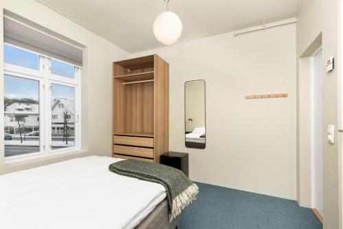 Schlafzimmer mit einem Bett und einem Fenster in der Unterkunft Central Guest House - Bedroom with private Bathroom in Stavanger