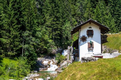 a small house next to a river at Residence Cavanis Wellness & Spa in Sappada