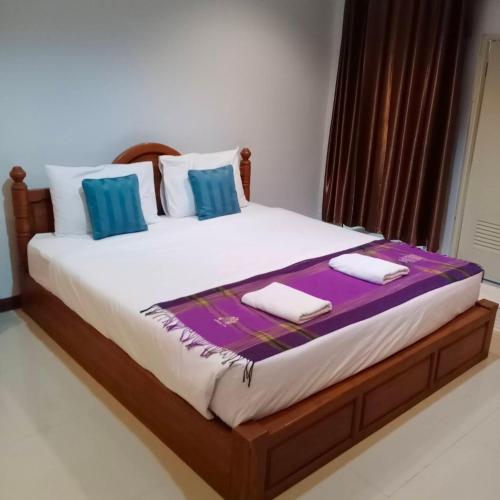 ein großes Bett mit zwei Kissen darüber in der Unterkunft โรงแรมข้าหลวงเพลส in Nan