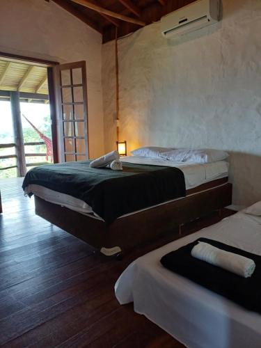 a bedroom with two beds and a light on the wall at Casa Morango in Praia do Rosa