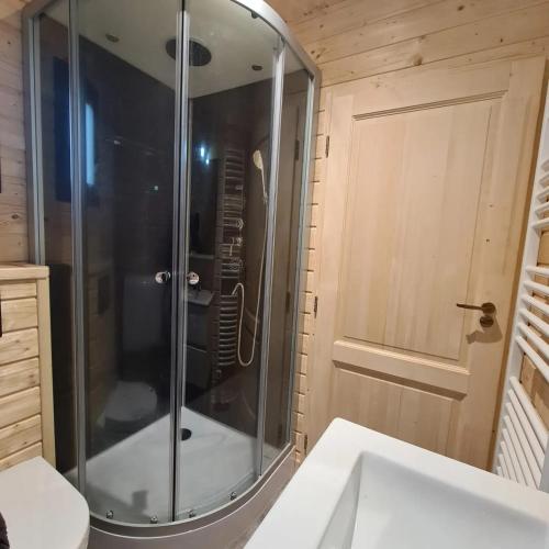 une douche avec une porte vitrée dans une salle de bain dans l'établissement Le tipi Cathare hébergement insolite Carcassonne, à Alairac