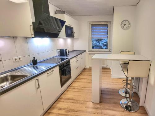 een keuken met witte kasten en een aanrecht bij 3 Zimmer Apartment in Wuppertal