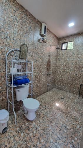 y baño con aseo y ducha. en Hotel Hacienda Angeles, en Paraíso