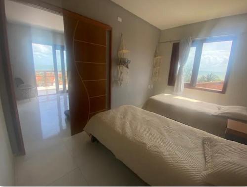 1 dormitorio con 2 camas y ventana en Casa da taty en Aracati