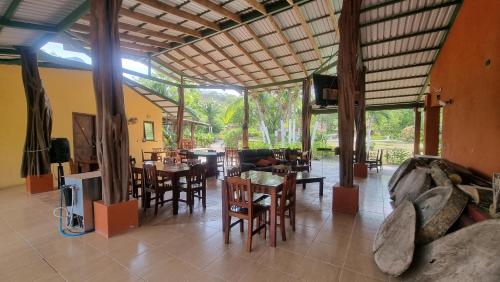 sala de estar con mesas, sillas y sofá en Hotel Hacienda Angeles, en Paraíso