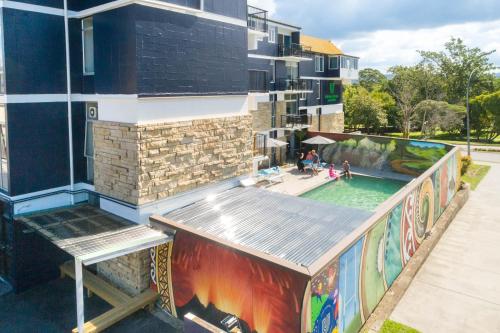 a building with a pool with a painting on it at Urban Lounge Sleepery in Rotorua