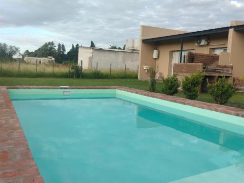 una piscina azul frente a una casa en La casita de Isa en Gualeguay