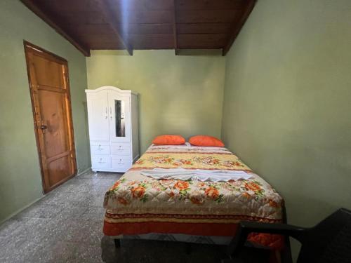 1 dormitorio con 1 cama con almohadas de color naranja en Cabaña de Atitlan, en Panajachel