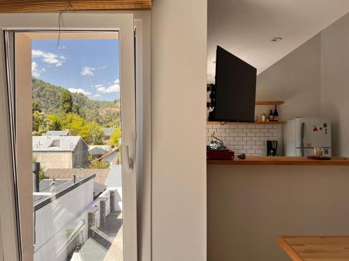 an open door to a kitchen with a view of a balcony at Aloha pinot Patagonia in San Martín de los Andes