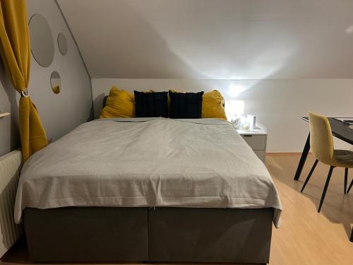 1 dormitorio con 1 cama grande con almohadas amarillas en Gemütliche Garconniere im Zentrum von Pregarten, en Pregarten