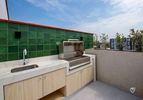 a kitchen with a sink and a green wall at New Full Apartment in Barranco in Lima