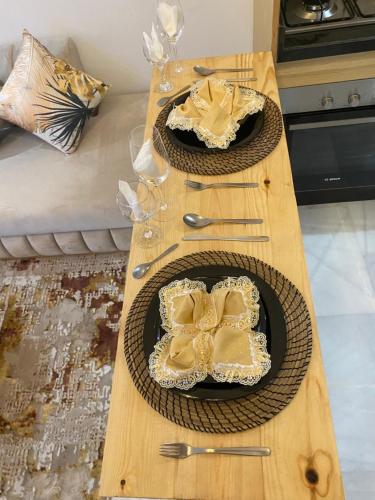 a wooden table with two plates of food on it at Élégance en 40 mètres Nouaceur in Nouaceur
